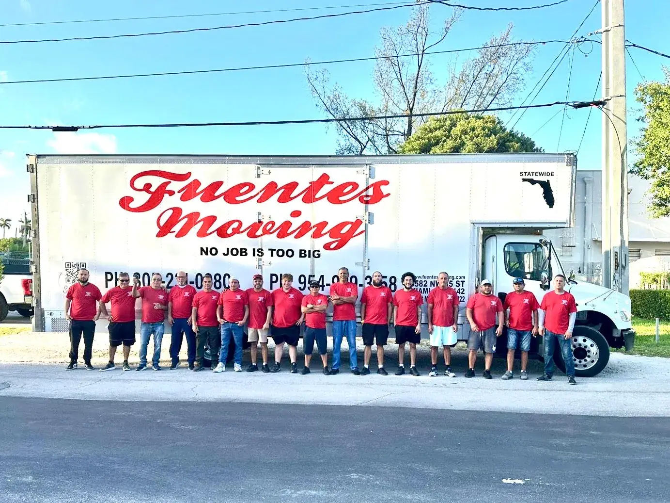 Fuentes Moving crew in red company shirts lined up in front of a branded Fuentes Moving truck