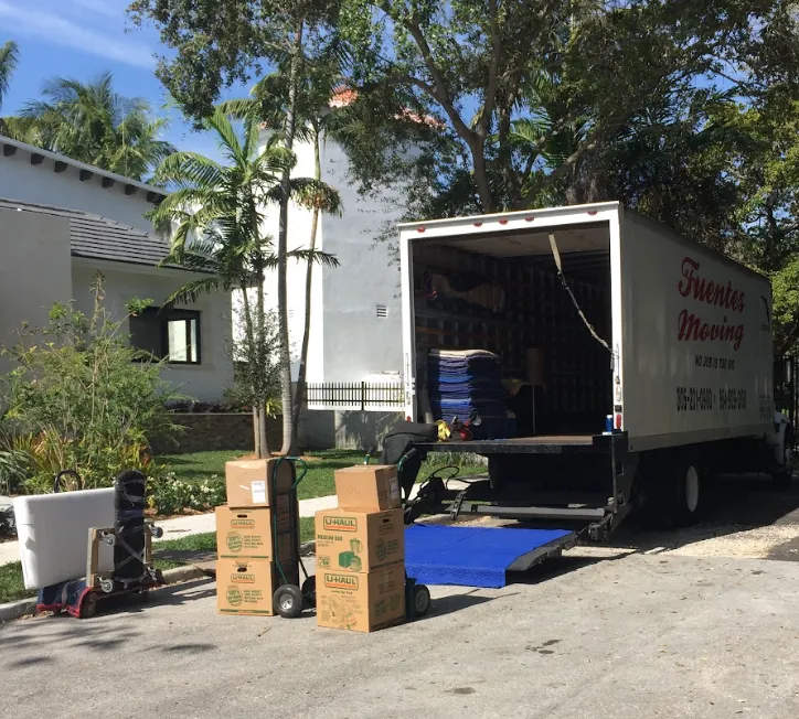 Fuentes Moving truck with open rear door and boxes staged on a driveway